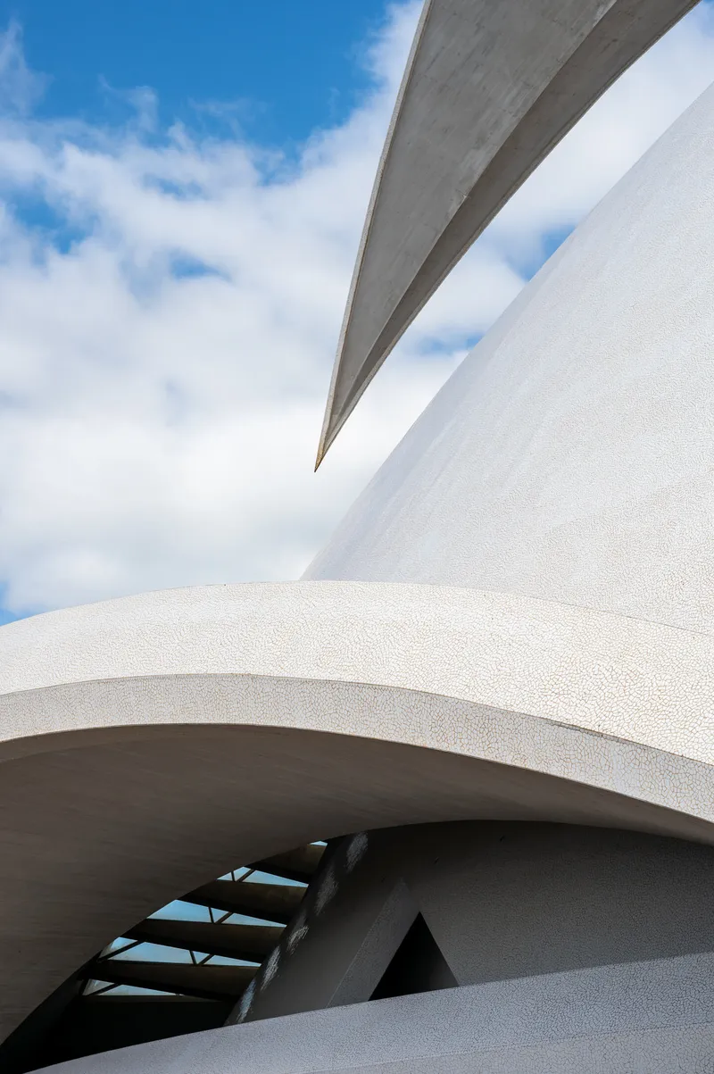 The main arch of the Auditorio de Tenerife meeting the mosaic-tiled dome, with ironwork visible below