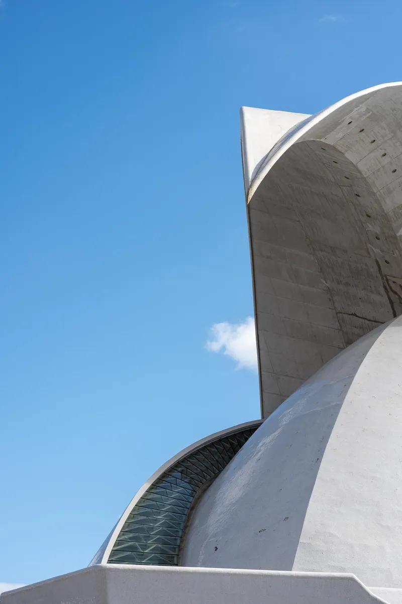 Glass strip and sharp concrete fin of the Auditorio de Tenerife, detail view against blue sky