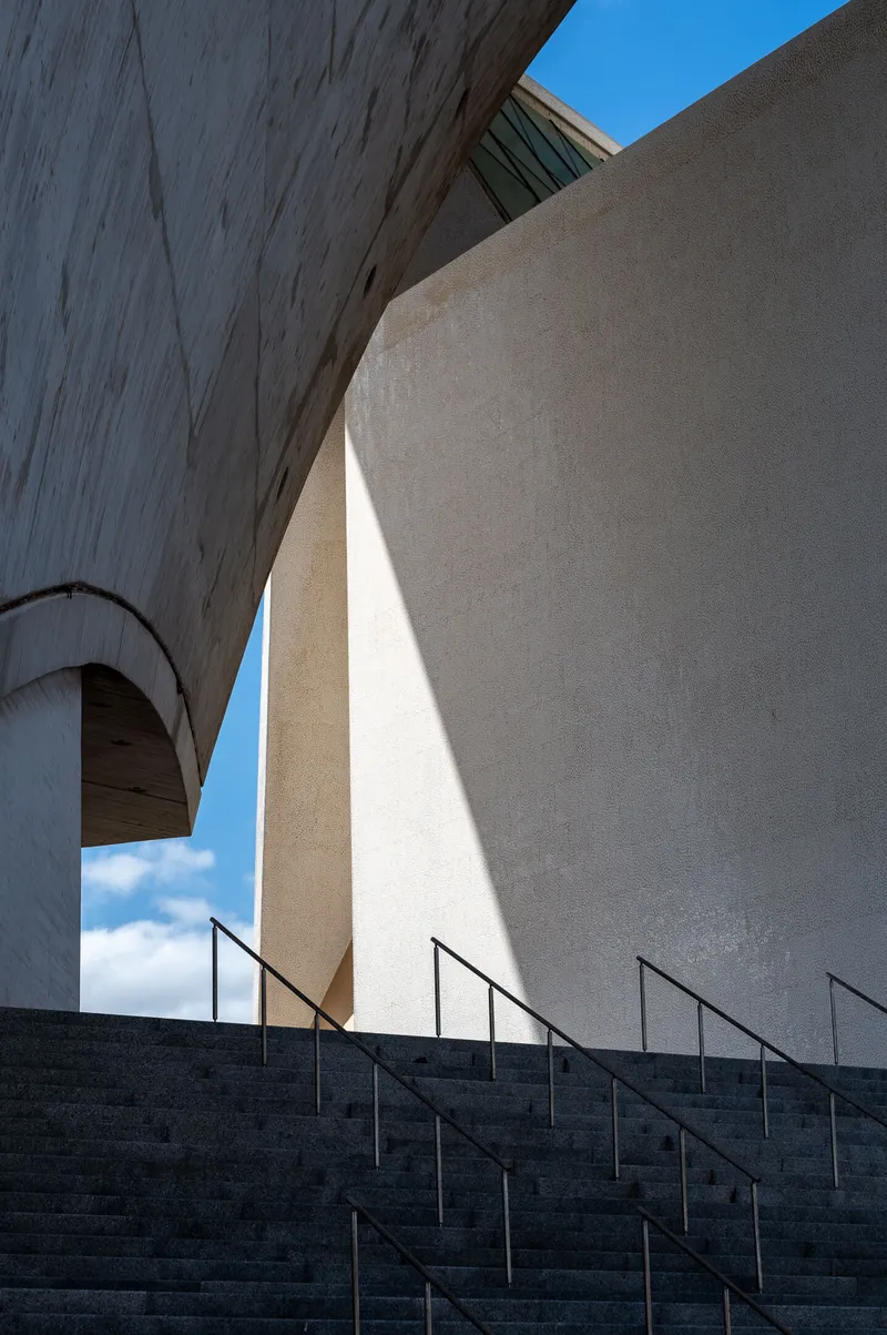 Concrete staircase and geometric shadow at the Auditorio de Tenerife, curved walls framing the composition