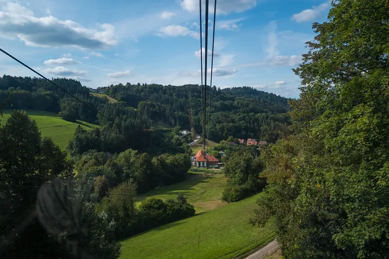 View from inside the Schauinslandbahn gondola looking down at the valley station and Horben village below, Black Forest, Leica Q2